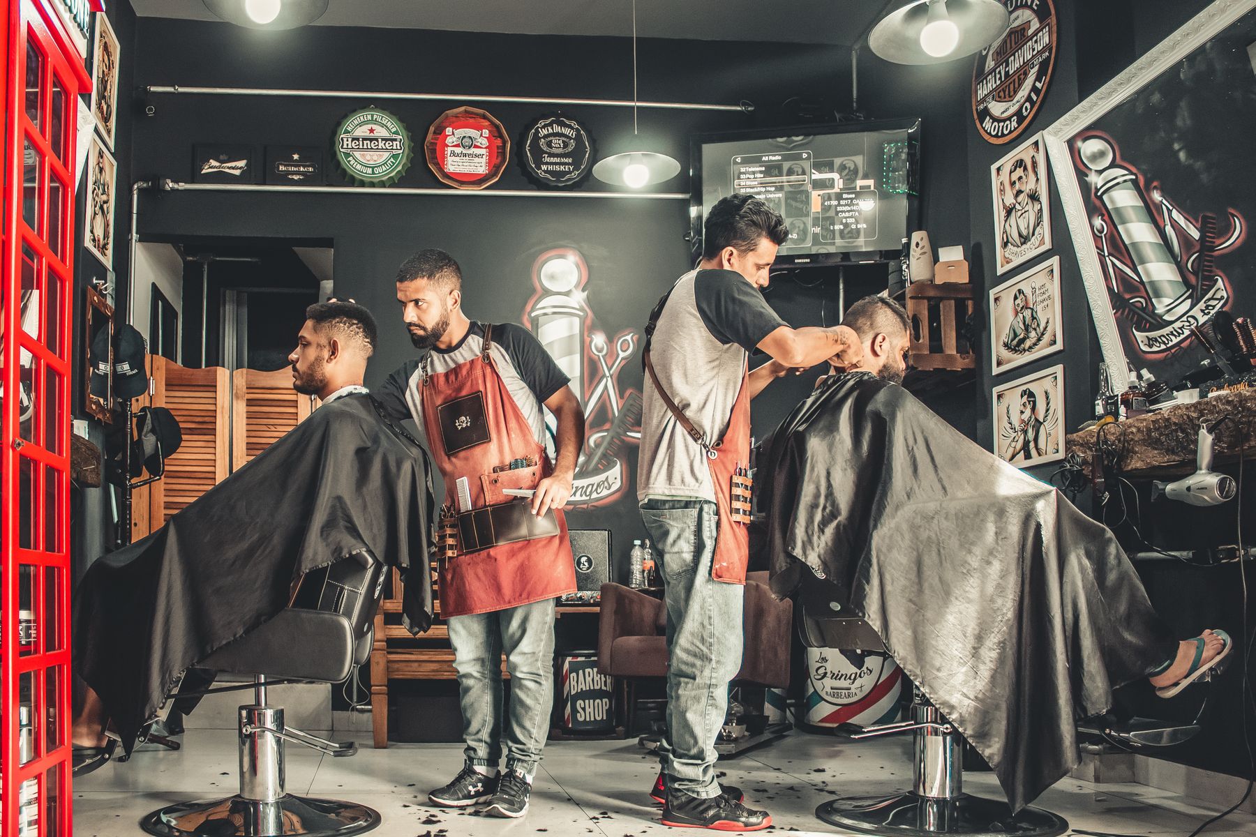 Barberos atendiendo clientes en una barbería